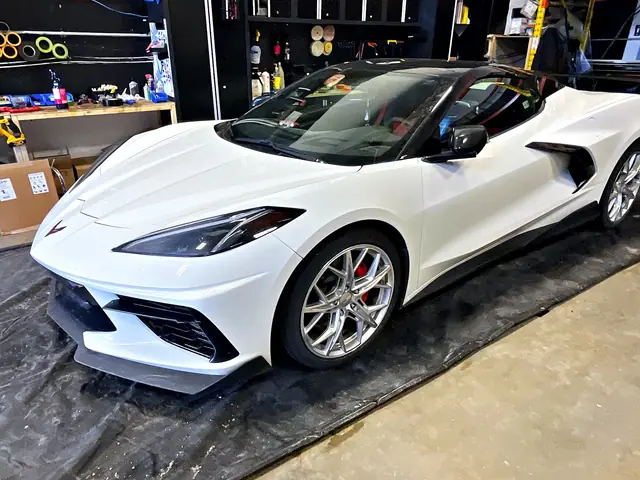 White Chevrolet Corvette convertible in the O Detail shop, front three-quarter view