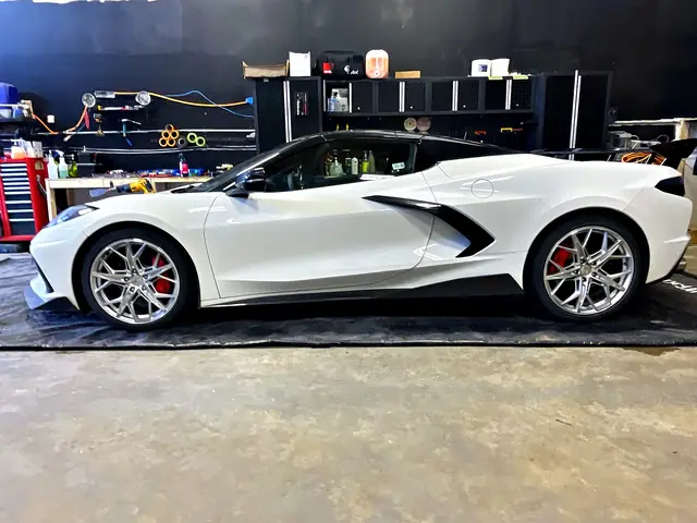 Side view of a white Chevrolet Corvette convertible in the O Detail shop