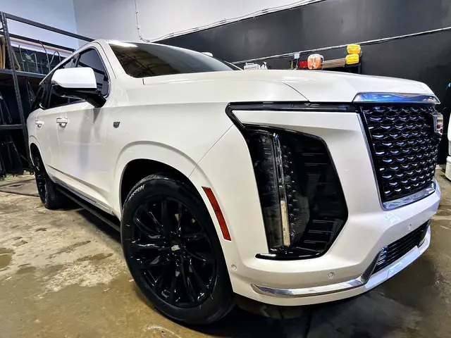 White Cadillac Escalade in the O Detail shop, front three-quarter view