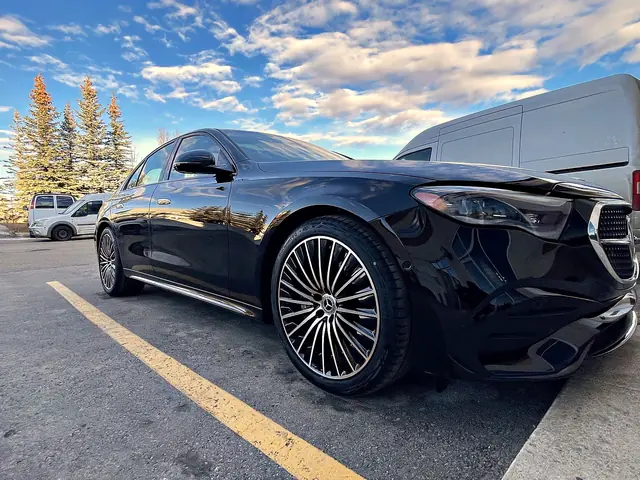 Black Mercedes-Benz E-Class with a clean, deep shine under a blue sky